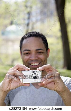 Picture - Man taking photograph in Central Park. Fotosearch