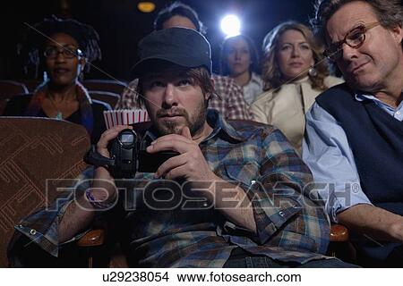 Man using video recorder in movie theatre View Large Photo Image Picture - Man using video recorder in movie theatre. Fotosearch