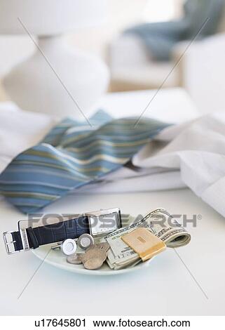 Stock Image - Men's items on a plate on dresser. Fotosearch