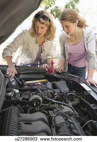 Mother and daughter looking under hood of car View Large Photo Image Stock Image - Mother and daughter looking under hood of car. Fotosearch