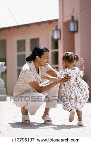 Mother and daughter playing on patio View Large Photo Image Stock Photo - Mother and daughter playing on patio. Fotosearch