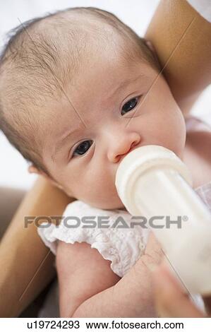 Stock Image - Mother feeding her baby a bottle. Fotosearch