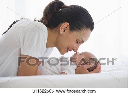 Stock Photography - Mother gazing at her sleeping baby. Fotosearch