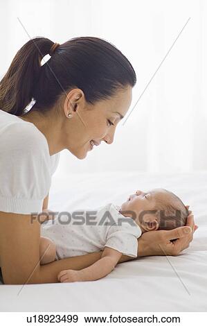 Stock Photo - Mother holding her sleeping baby. Fotosearch