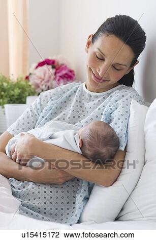 Mother holding newborn baby in hospital bed View Large Photo Image Stock Image - Mother holding newborn baby in hospital bed. Fotosearch