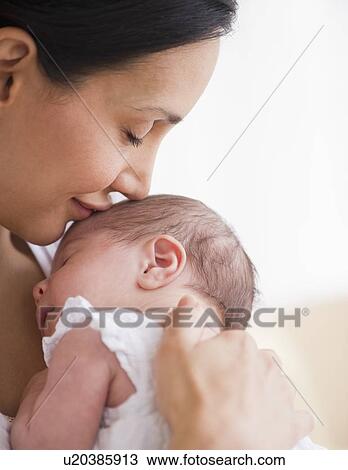 Mother kissing her baby's head View Large Photo Image Stock Image - Mother kissing her baby's head. Fotosearch