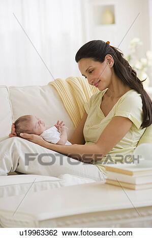 Mother sitting on couch with her baby View Large Photo Image Stock Image - Mother sitting on couch with her baby. Fotosearch