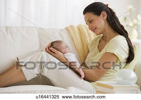 Mother sitting on couch with her baby View Large Photo Image Stock Photography - Mother sitting on couch with her baby. Fotosearch