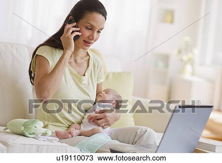 Mother talking on phone while holding her baby View Large Photo Image Stock Image - Mother talking on phone while holding her baby. Fotosearch