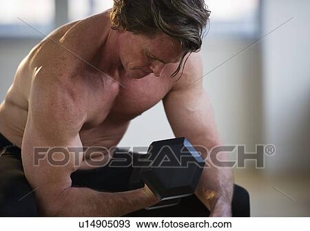 Stock Image - Muscular man lifting free weight. Fotosearch