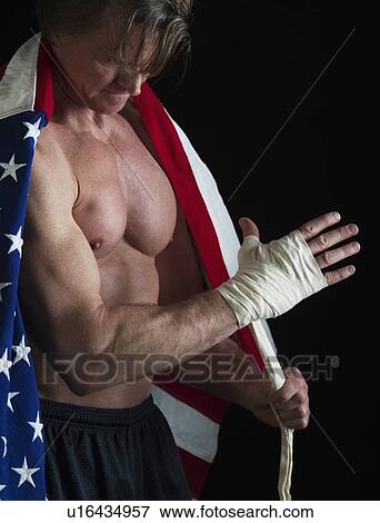 Stock Photo - Muscular man wearing American flag as a cape. Fotosearch