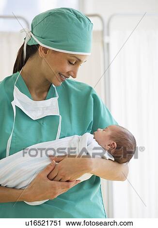 Nurse holding swaddled baby View Large Photo Image Stock Image - Nurse holding swaddled baby. Fotosearch