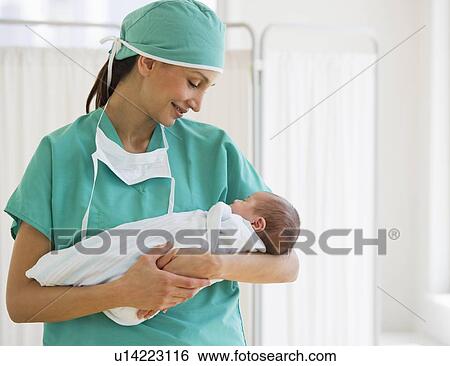 Stock Photograph - Nurse holding swaddled baby. Fotosearch
