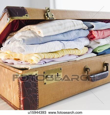 Stock Image - Overflowing suitcase. Fotosearch