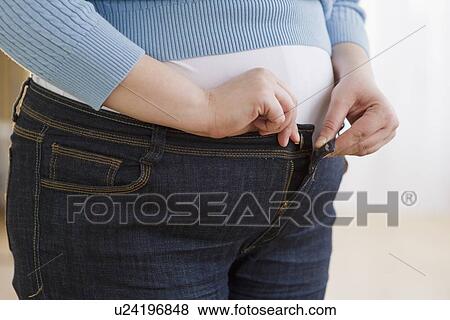 Overweight woman buttoning up her jeans View Large Photo Image Stock Photo - Overweight woman buttoning up her jeans. Fotosearch