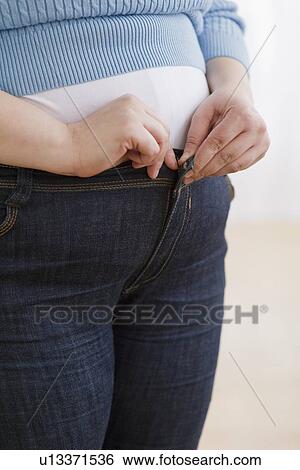 Overweight woman buttoning up her jeans View Large Photo Image Stock Photograph - Overweight woman buttoning up her jeans. Fotosearch