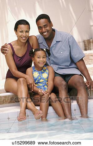 Parents and their daughter sitting on edge of pool together View Large Photo Image Stock Photo - Parents and their daughter sitting on edge of pool together. Fotosearch
