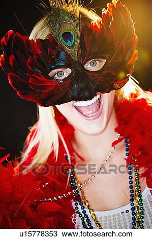 Stock Image - Person wearing a mardi grass mask and beads. Fotosearch