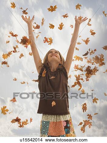 Pretty teenage girl throwing leaves in the air View Large Photo Image Picture - Pretty teenage girl throwing leaves in the air. Fotosearch