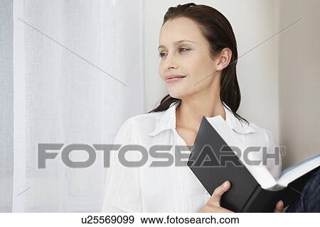 Stock Photo - Pretty woman holding a book. Fotosearch