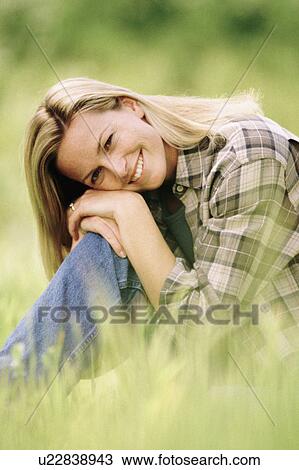 Pretty woman relaxing on grass in meadow View Large Photo Image Stock Image - Pretty woman relaxing on grass in meadow. Fotosearch