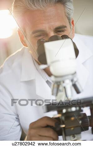 Researcher looking through microscope View Large Photo Image Stock Image - Researcher looking through microscope. Fotosearch