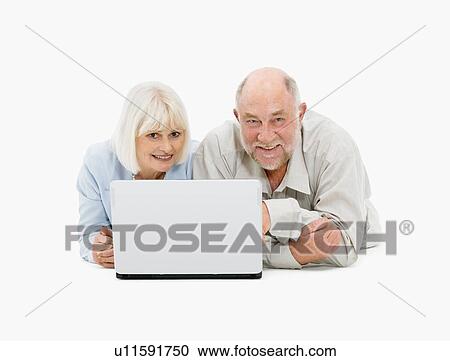 Retired couple looking at laptop together View Large Photo Image Stock Image - Retired couple looking at laptop together. Fotosearch