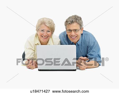 Stock Photo - Retired couple looking at laptop together. Fotosearch