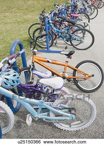 Stock Photograph - Row of children's bicycles locked up in school yard. Fotosearch