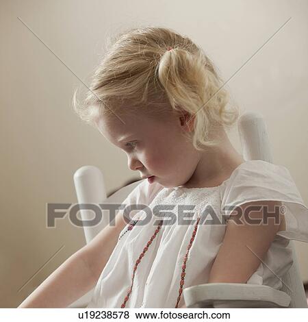Sad young girl sitting in rocking chair View Large Photo Image Stock Photo - Sad young girl sitting in rocking chair. Fotosearch