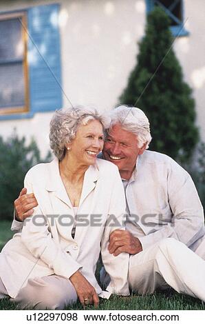 Stock Photo - Senior couple relaxing on lawn together. Fotosearch