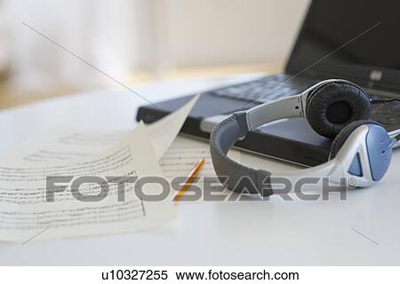 Stock Photography - Sheet music headphones and laptop. Fotosearch