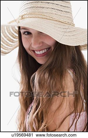 Stock Image - Smiling long haired woman wearing a straw hat. Fotosearch