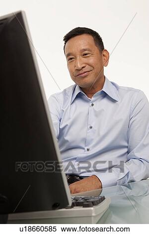 Smiling man working on computer View Large Photo Image Stock Photography - Smiling man working on computer. Fotosearch