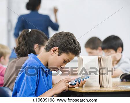 Stock Photo - Student texting in classroom. Fotosearch
