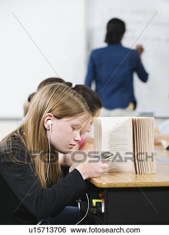 Stock Photograph - Student texting in classroom. Fotosearch