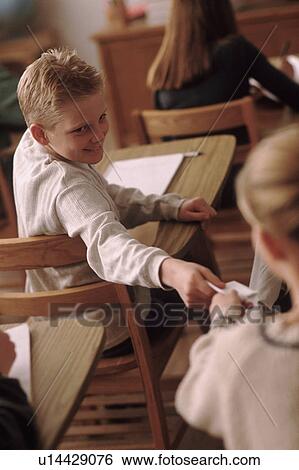 Students passing a note in classroom View Large Photo Image Stock Photograph - Students passing a note in classroom. Fotosearch