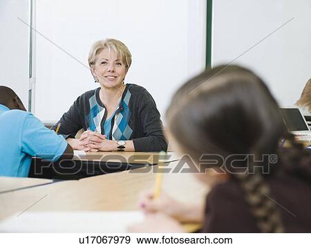 Teacher watching over students in elementary classroom View Large Photo Image Stock Photo - Teacher watching over students in elementary classroom. Fotosearch