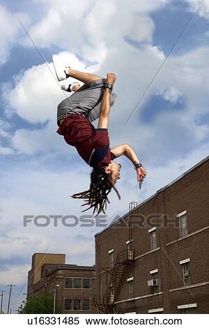Teenage boy doing back flip in air View Large Photo Image Stock Photography - Teenage boy doing back flip in air. Fotosearch