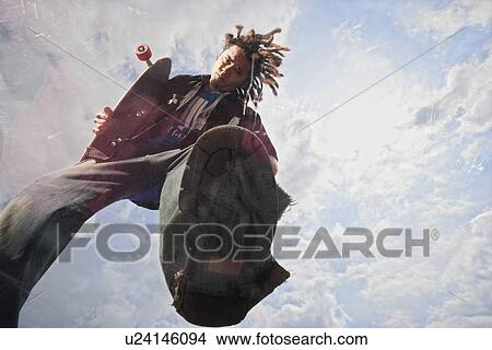 Picture - Teenage boy doing skateboard jump. Fotosearch