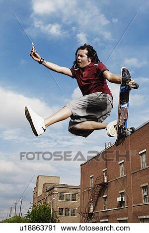Stock Image - Teenage boy doing skateboard jump. Fotosearch