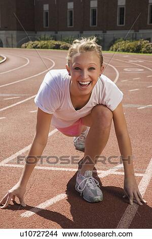 Picture - Teenage girl getting ready to run a race. Fotosearch