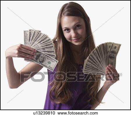Stock Image - Teenage girl holding several 100 dollar bills. Fotosearch
