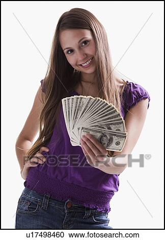 Stock Image - Teenage girl holding several 100 dollar bills. Fotosearch