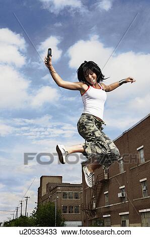 Stock Image - Teenage girl jumping in the air. Fotosearch