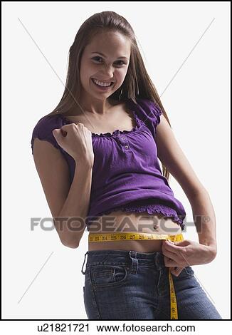 Stock Image - Teenage girl measuring her waist. Fotosearch