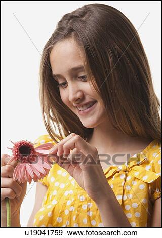 Stock Photo - Teenage girl picking petals off of a flower. Fotosearch