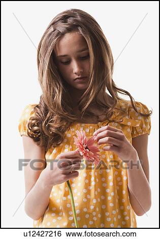 Stock Photograph - Teenage girl picking petals off of a flower. Fotosearch