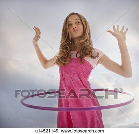 Stock Photo - Teenage girl playing with a hula hoop. Fotosearch