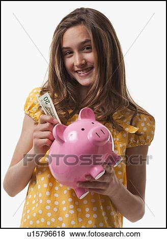Teenage girl putting money in piggy bank View Large Photo Image Stock Photo - Teenage girl putting money in piggy bank. Fotosearch